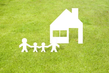 Family Home Of Paper Cut On Grass Background